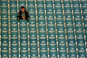 Ein einzelner Mann auf der Tribüne eines Sportstadions