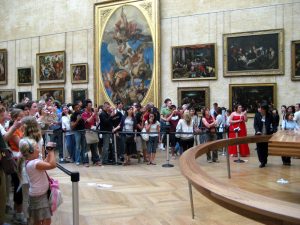 Vor der Mona Lisa im Louvre. Bilder sind mit vergoldeten Rahmen ausgestattet.