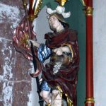 St. Florian. Gefasste Holzskulptur an einer Kirchenwand